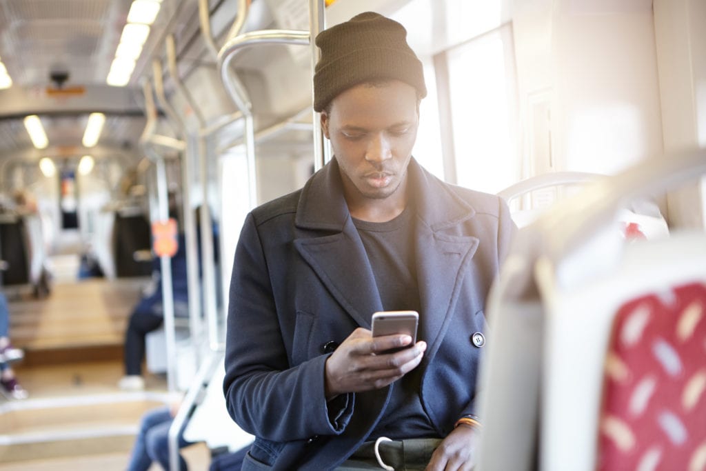 young man looking at his phone on a train